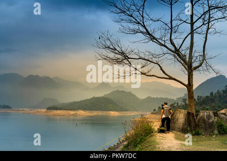 Un fotografo è tenuto il paesaggio di foto in una splendida alba a Na Hang lago, Tuyen Quang provincia, Vietnam Foto Stock