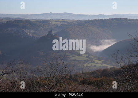 Najac castle e l'Aveyron valle nell'autunno del sole al mattino, con nebbia nella valle. Foto Stock