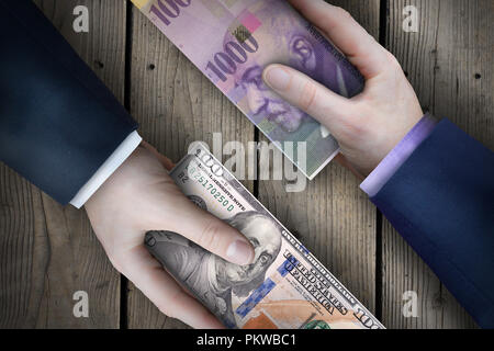 Due fiat valuta le fatture che vengono scambiati da due uomini di affari che come parte di una transazione commerciale. Foto Stock