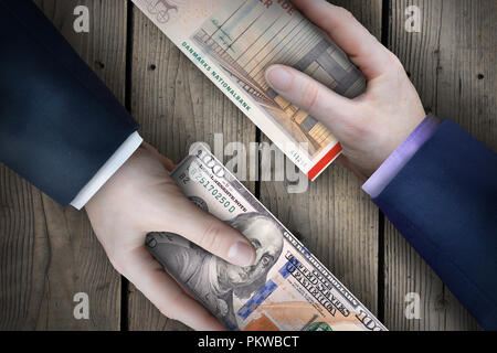 Due fiat valuta le fatture che vengono scambiati da due uomini di affari che come parte di una transazione commerciale. Foto Stock