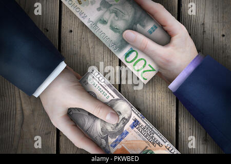 Due fiat valuta le fatture che vengono scambiati da due uomini di affari che come parte di una transazione commerciale. Foto Stock