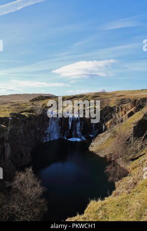 Regno Unito, Cumbria, Coniston. Vista verso la cascata ghiacciata dalla cava Banishead Torver comune nel Lake District inglese. Foto Stock