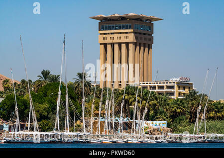 Movenpick Hotel resort torre di cemento con tradizionale feluca e barche a vela, Fiume Nie, Aswan, Egitto, Africa Foto Stock