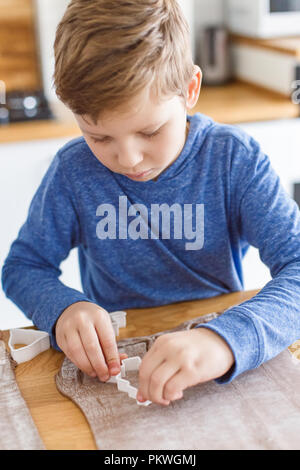 Ragazzo realizzato biscotti di Natale a casa Foto Stock