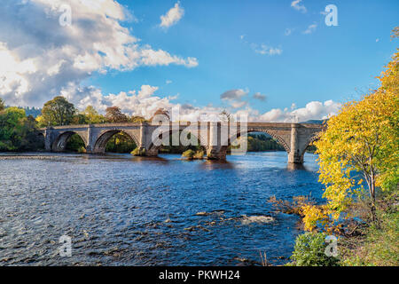 Autunno glow in una giornata di sole su Thomas Telford progettato ponte a Dunkeld Perthshire Scozia. Si attraversa il fiume Tay, il fiume più lungo in Scozia Foto Stock