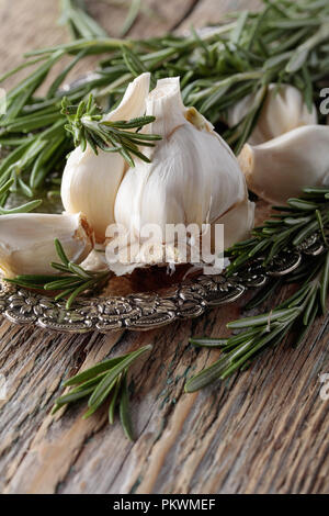 Il rosmarino e aglio su un vecchio tavolo di legno. Foto Stock