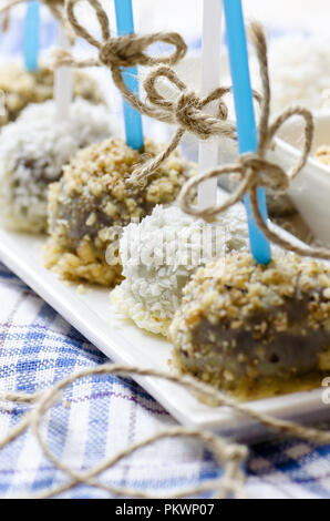 Cakepops al cioccolato con noci e scaglie di cocco. Close up. Foto Stock