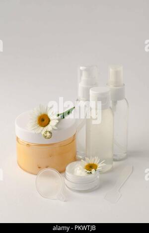 Cosmetici contenitori Vaso con fiori camomole, etichetta vuota package per il branding mock-up, naturale bellezza organica concezione del prodotto Foto Stock