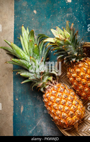 Due ananas in un cesto di vimini, vista dall'alto Foto Stock