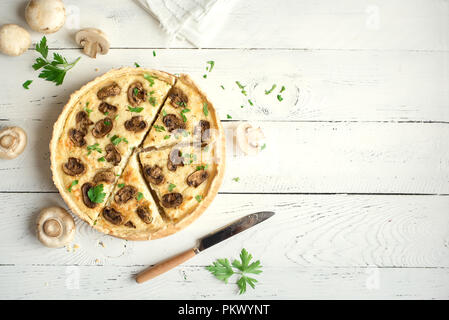 Sformatino di funghi torta con champignon e formaggio bianco su sfondo di legno, vista dall'alto. Torta salata con funghi. Foto Stock