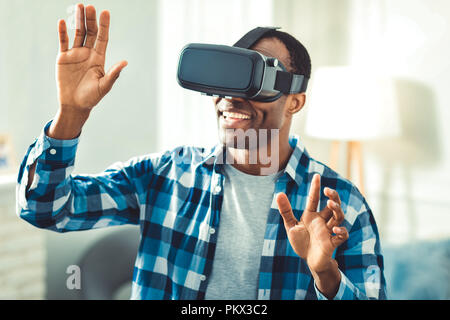 Felice afro-americano utilizzando occhiali VR Foto Stock