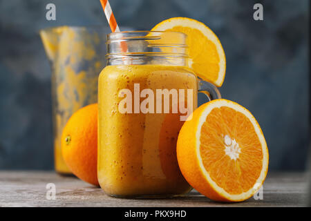 Vitamina bere: frullati da arance fresche in un vasetto di vetro su di un tavolo di legno, close-up Foto Stock