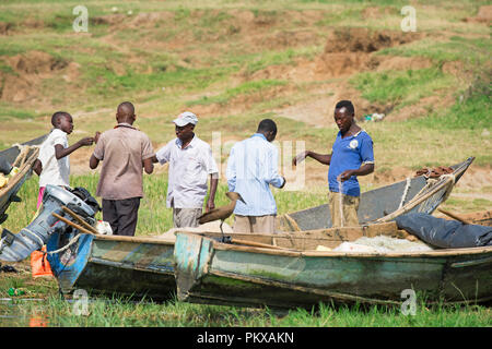 Ispezione dei pescatori, lavorando con le proprie reti e villaggio di pescatori sul canale Kazinga, Queen Elizabeth National Park, Uganda Foto Stock