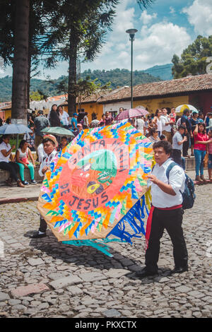 2018: Bambini tenere decorazioni colorate come essi marzo nei cortei per il Dia de la Independencia (giorno dell'indipendenza) in Guatemala Foto Stock