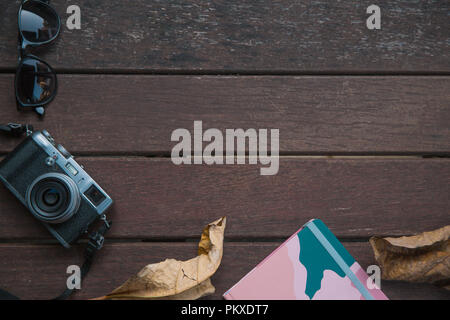Composizione di autunno e accessori. Foglie di autunno, fotocamera retrò, notebook. Appartamento laico, vista dall'alto. Il concetto di moda Foto Stock