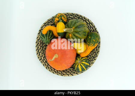 Diverse varietà di zucca in una decorativa liberiane cestello Studio shot su sfondo bianco, vista da sopra Foto Stock