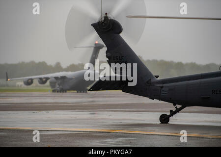 Avieri e attrezzature da 334 Aria Gruppo Expeditionary arrivati alla base comune a bordo di Charleston HC-130J contro il re II aeromobili e HH-60G spianare i falchi da Moody Air Force Base, Sett. 15, 2018. La AEG 334 sono pre-posizionato in modo da essere pronti a fornire sollievo nella scia della tempesta tropicale Firenze. La 334 AEG è un ricerca expeditionary e unità di salvataggio composta da 23d Ala e 920th ala di salvataggio personale e risorse pronte per eseguire la superficie, ad ala fissa e rotante operazioni SAR quando necessario. (U.S. Air Force Foto di Technical Sgt. Chris Hibben) Foto Stock