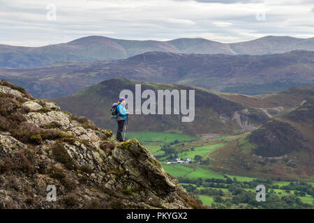 Un viandante si gode della vista sulla valle di Newlands da Ard dirupi, Lake District, Cumbria, Regno Unito Foto Stock