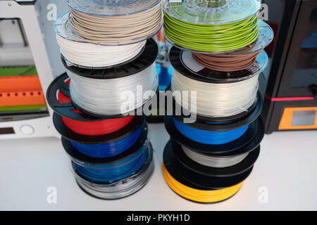 ABS e PLA filament accanto alla stampante 3D. Bobine di plastica Foto Stock