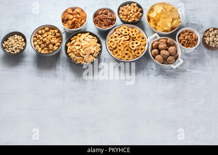 Diversi i ragazzi di spuntini, patatine, dadi e popcorn con copia spazio. Vista superiore Foto Stock