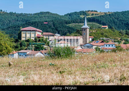Il paesaggio nei Pirinei puoi vedere il villaggio Erro in cui la torre della parrocchia di San Esteban spicca. Navarra Spagna Foto Stock