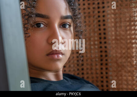 Piscina ritratto della bella felice razza mista americano africano ragazza adolescente riflessivo femmina, triste o depresso, giovane donna Foto Stock