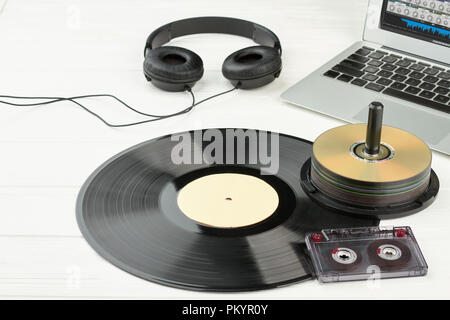 Moderno e dispositivi obsoleti e gadget. Desk del musicista o cantautore con laptop, cuffie, vinile, compact disc e cassette audio. Evol Foto Stock