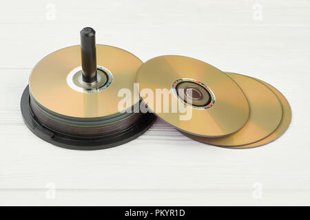 Pila di compact disc su sfondo bianco. Gruppo di dischi vuoti sulla superficie di legno. Memorizzazione digitale di informazioni. Foto Stock