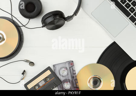 Tabella con audio musica tecnologie. Il telaio dal laptop, vinile, auricolari, compact disc e audio cassette con copia spazio. E obsoleti Foto Stock