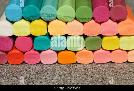 Colorazione a matita cerosa bastoni in molti colori differenti impilati sullo sfondo di granito con taglio a trama Foto Stock