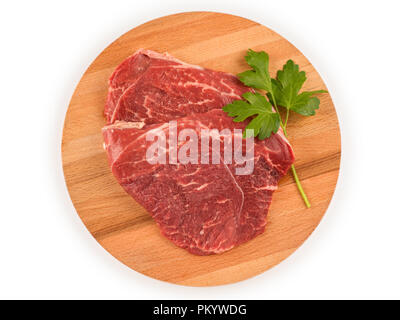 La carne cruda di bistecca sul round tagliere di legno. Vista dall'alto isolato su bianco, percorso di clipping incluso Foto Stock