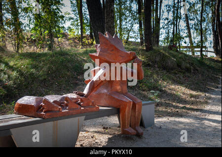 SAULKRASTI, Lettonia - Agosto 2018: la figura di hedgehog in legno è seduta su una panchina Foto Stock