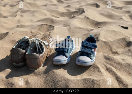 Vista ravvicinata su scarpe abbandonate e giallo sabbia Foto Stock