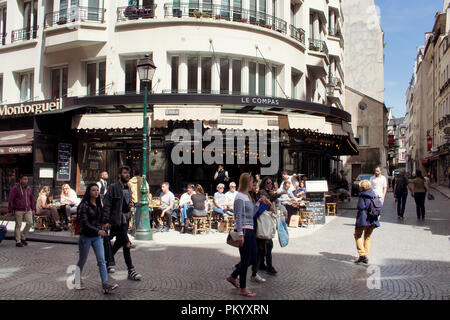 La gente a piedi sulla famosa Rue Montorgueil street a Parigi. Un caffè tradizionale / bistro place è anche nella vista . Foto Stock