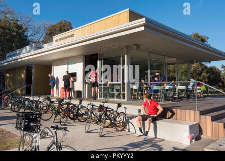 Le Biciclette parcheggiate e piloti il resto e bere un caffè presso la caffetteria Serra nel sole di mattina a Centennial Park, Sydney Australia Foto Stock