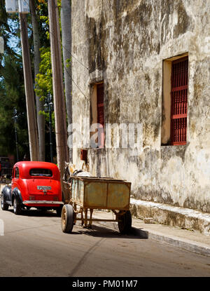 Un antico auto parcheggiate davanti a un cavallo e buggy illustrante le dure condizioni di vita in una piccola città in Cuba il 25 agosto, 2018 Foto Stock