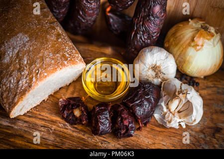 Still Life foto di il salame chorizo aglio cipolla olio di oliva pane tradizionale cucina isolato Foto Stock