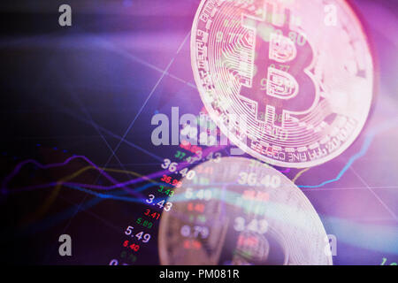 Bitcoin moneta in oro e sfocati sullo sfondo del grafico. Virtual crypto concetto di valuta Foto Stock