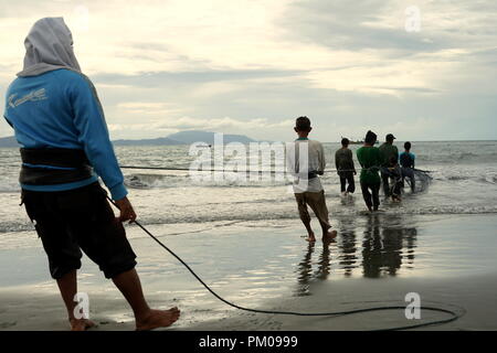 Di Banda Aceh e Aceh, Indonesia - 16 Settembre 2018: gruppo di pescatori tira manualmente i loro net fuori dall'oceano a Gampong Jawa Beach, Banda Aceh Foto Stock