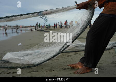 Di Banda Aceh e Aceh, Indonesia - 16 Settembre 2018: gruppo di pescatori tira manualmente i loro net fuori dall'oceano a Gampong Jawa Beach, Banda Aceh Foto Stock