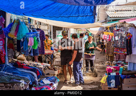 Locale uomo del Kirghizistan saluto e stringe la mano ad un turista nel grande Bazaar a Karakol, Kirghizistan. Foto Stock