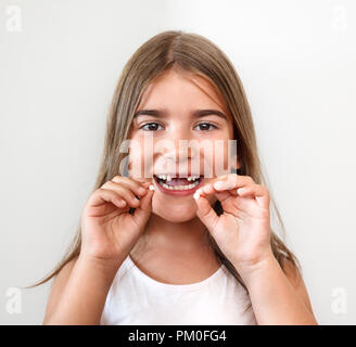 Piccola ragazza che mantiene i denti Foto Stock