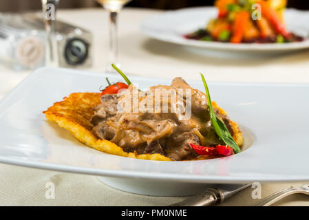 Carni bovine stroganoff con frittelle pomodori e peperoni, frittelle di patate Foto Stock