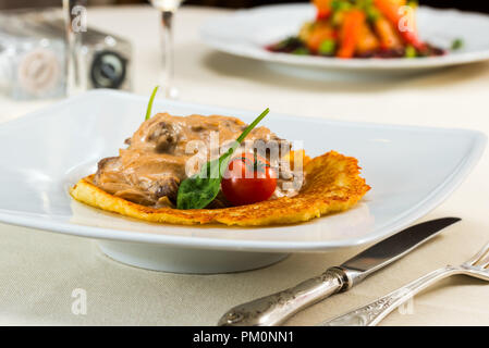 Carni bovine stroganoff con frittelle pomodori e peperoni, frittelle di patate Foto Stock