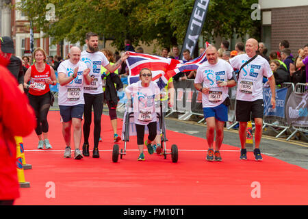 Warrington, Regno Unito. 16 settembre 2018. L'inglese mezza maratona, EHM, celebra il suo decimo anno nel 2018. La pioggia era stato previsto per l'evento ma dopo un iniziale raccolta umido il tempo umido tenuto spento fino alla fine della corsa. A partire da una griglia ammassato nella line-up Winmarleigh Street, Warrington, Cheshire, Inghilterra, il corso segue le strade della città e si conclude attraversando il tappeto rosso fine attraverso l'iconica Golden Gates di Warrington Town Hall. Credito: John Hopkins/Alamy Live News Foto Stock