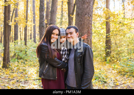 Caduta, della natura e del concetto di famiglia - Ritratto di famiglia felice su autunno sfondo parco Foto Stock