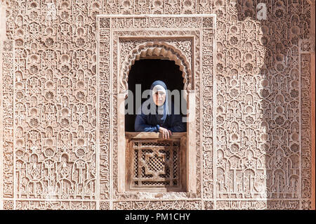 26-02-15, Marrakech, Marocco. Una donna in abito tradizionale guarda attraverso una finestra della medersa Ben Youssef, o il figlio di Giuseppe scuola. Foto © SIM Foto Stock