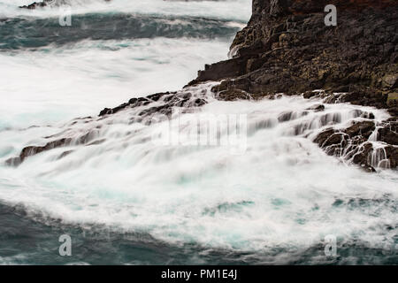 Il selvaggio Oceano Atlantico si infrange contro le rocce lungo la riva occidentale delle Isole Shetland a Eshaness Foto Stock