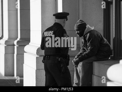 Stati Uniti - Feb 4: Un poliziotti Amtrak prassi di applicazione della legge motto, ÒTo proteggere e serveÓ come egli controlli su un senzatetto durante la sua r Foto Stock