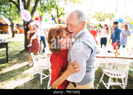 Un senior coppia danzante su un party in giardino al di fuori nel cortile. Foto Stock